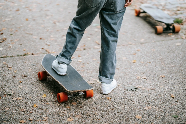 a person standing on a skateboard on a street, trending on pexels, blue jeans and grey sneakers, at a park, white background, sustainable materials