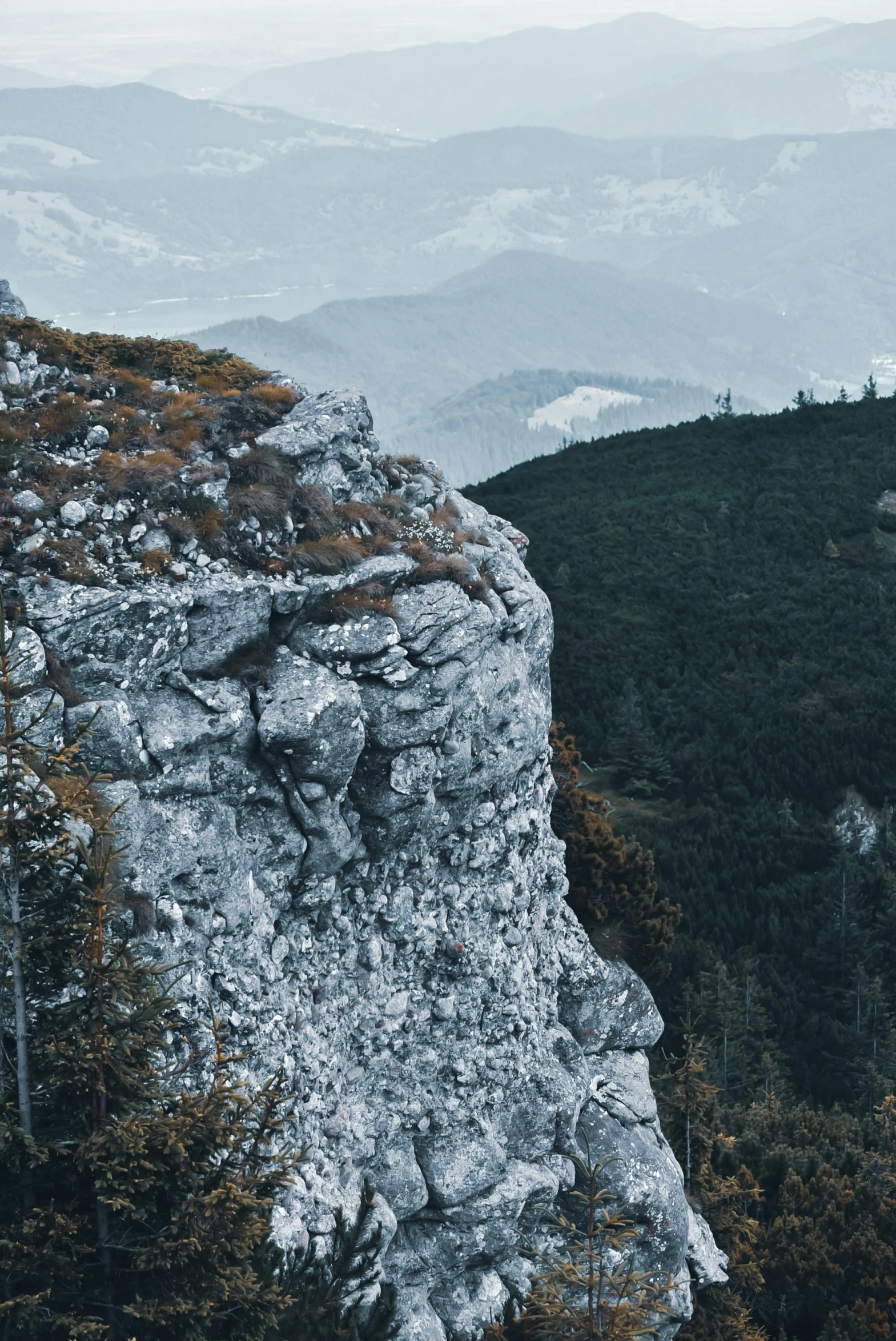 a person standing on top of a mountain, by Adam Szentpétery, romanticism, 8k detail post processing, rocky cliff, telephoto shot, unsplash 4k