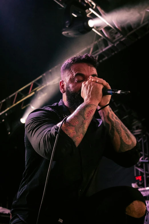 a man on stage singing into a microphone, a tattoo, clayton crain, instagram picture, eyes closed, promo image