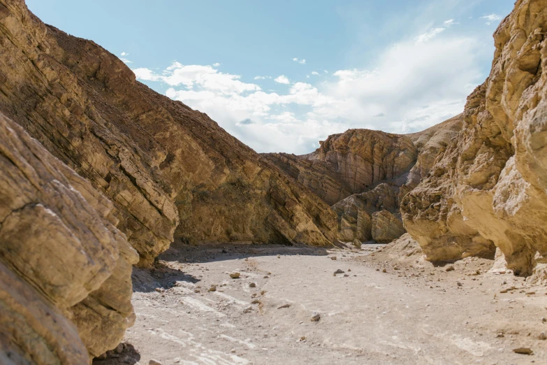 a person riding a horse through a canyon, by Julia Pishtar, unsplash contest winner, les nabis, death valley, gravel and scree ground, on a bright day, sulfur