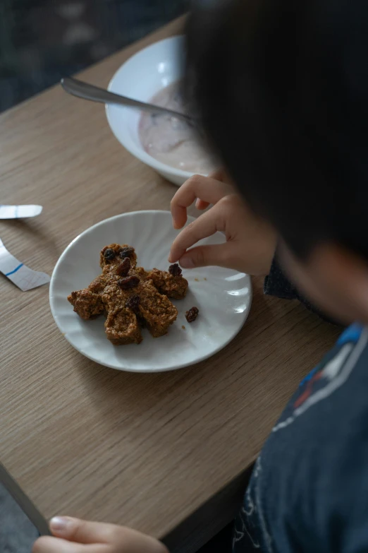 a person sitting at a table with a plate of food, cereal, nugget, boys, cinnamon