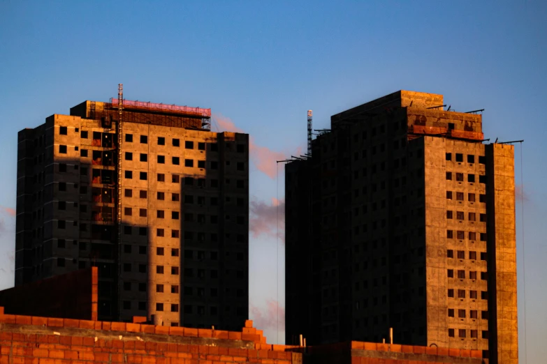 a couple of tall buildings sitting next to each other, inspired by Elsa Bleda, unsplash, brutalism, under construction, golden hour photo, 2000s photo, today\'s featured photograph 4k