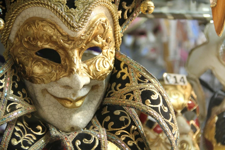 a close up of a gold and black mask, a photo, flickr, baroque, square, a brightly coloured, venice, trending photo