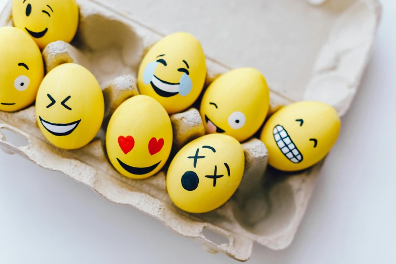 a carton of eggs with smiley faces painted on them, a cartoon, trending on pexels, 😃😀😄☺🙃😉😗, yellow, instagram post, emotive faces