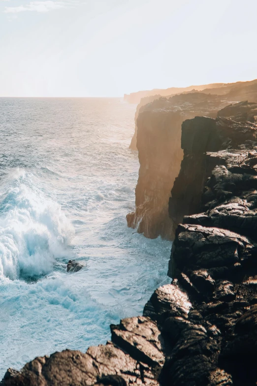 a person standing on top of a cliff next to the ocean, big island, rough waters, instagram post, manly