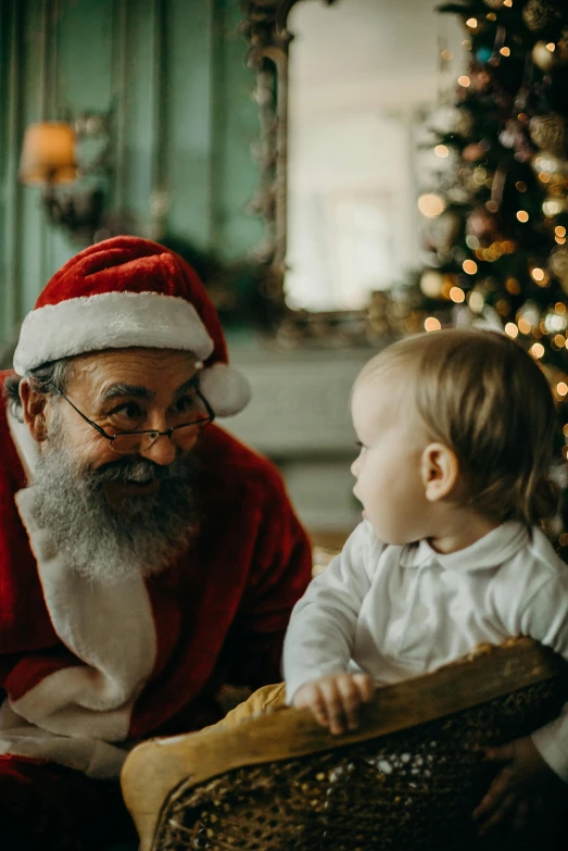 a man sitting next to a baby in front of a christmas tree, pexels contest winner, white beard, thumbnail, joyful look, texture