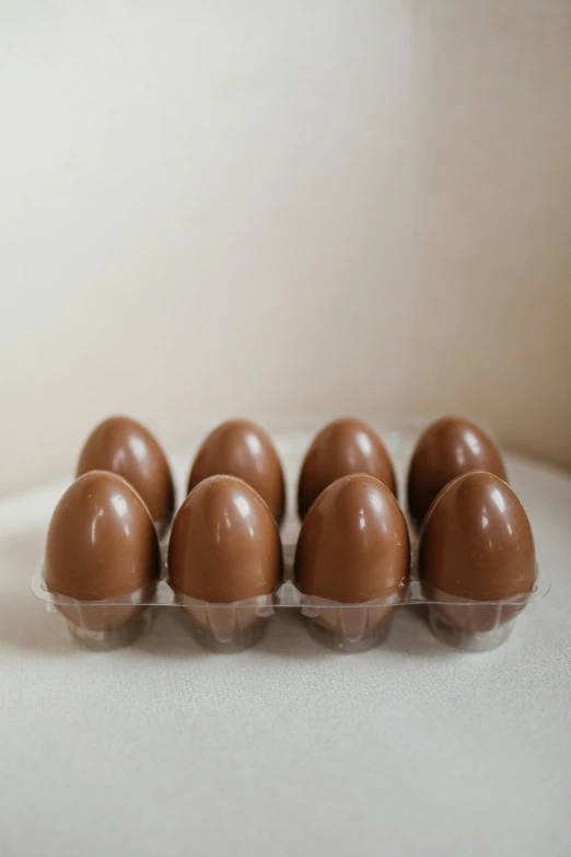 a tray of chocolate eggs sitting on top of a counter, 8 x, super smooth, caramel, thumbnail