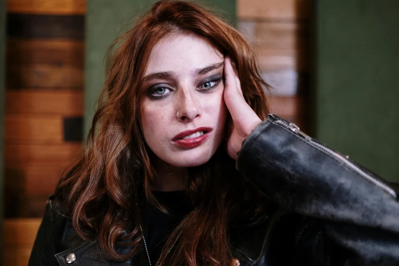 a close up of a person wearing a leather jacket, a portrait, inspired by Elsa Bleda, trending on pexels, renaissance, ( redhead, beautiful jewish woman, square, casual pose