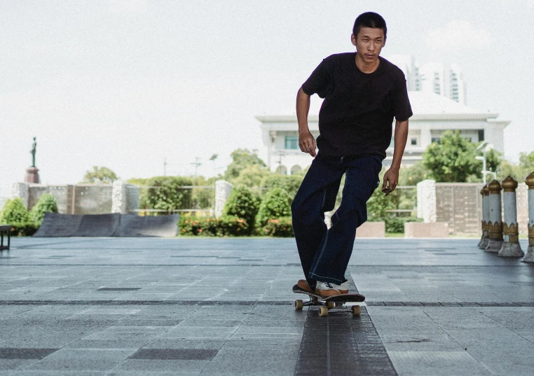 a man riding a skateboard down a sidewalk, pexels contest winner, asian male, wearing pants and a t-shirt, carving, sydney park