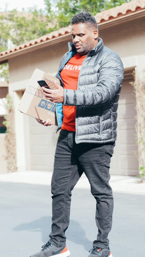 a man standing on a street holding a box, future inflatable jacket, 🥥 🍕 hybrid, press photos, profile picture