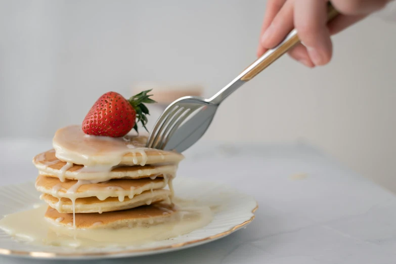 a stack of pancakes with syrup and a strawberry on top, unsplash, metal kitchen utensils, silver，ivory, background image, pouring