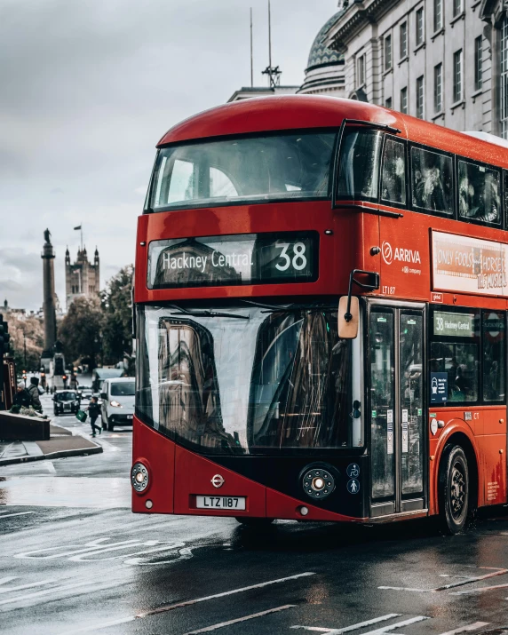 a red double decker bus driving down a street, 🚿🗝📝, popular on instagram, overcast weather, thumbnail