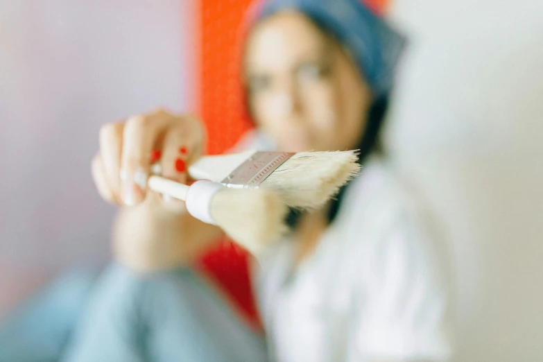 a woman brushing her teeth with a brush, a photorealistic painting, pexels contest winner, holding a paintbrush, white, buff painting, blurred detail