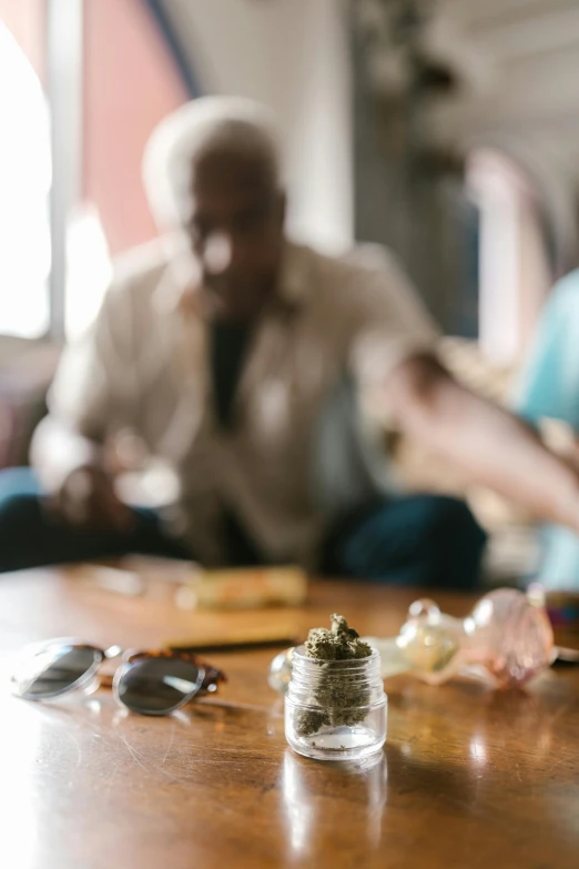 a group of people sitting around a wooden table, pot leaf, on a table