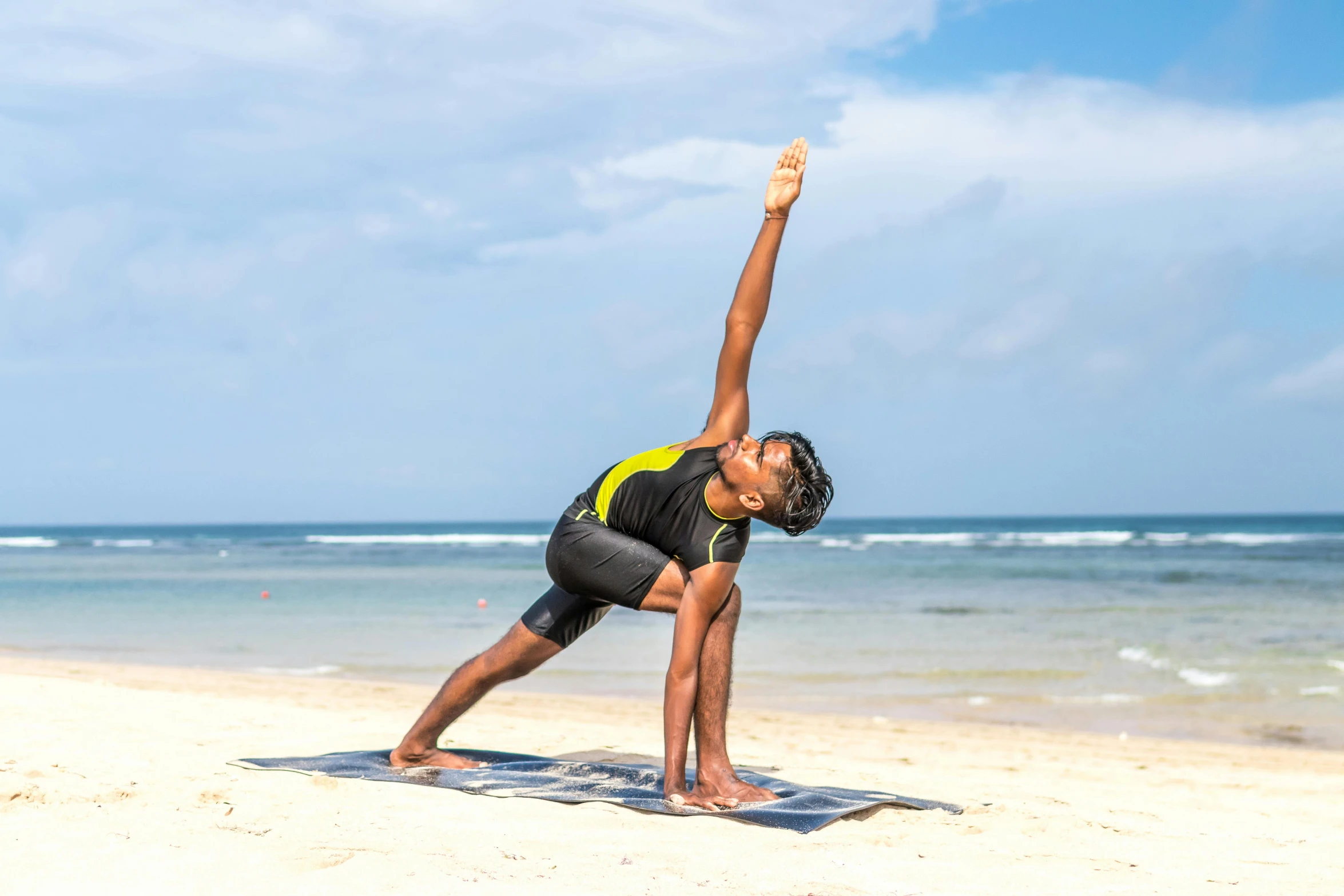 a woman doing a yoga pose on the beach, pexels contest winner, tsunami behind him, sydney park, sarong, mohamed chahin