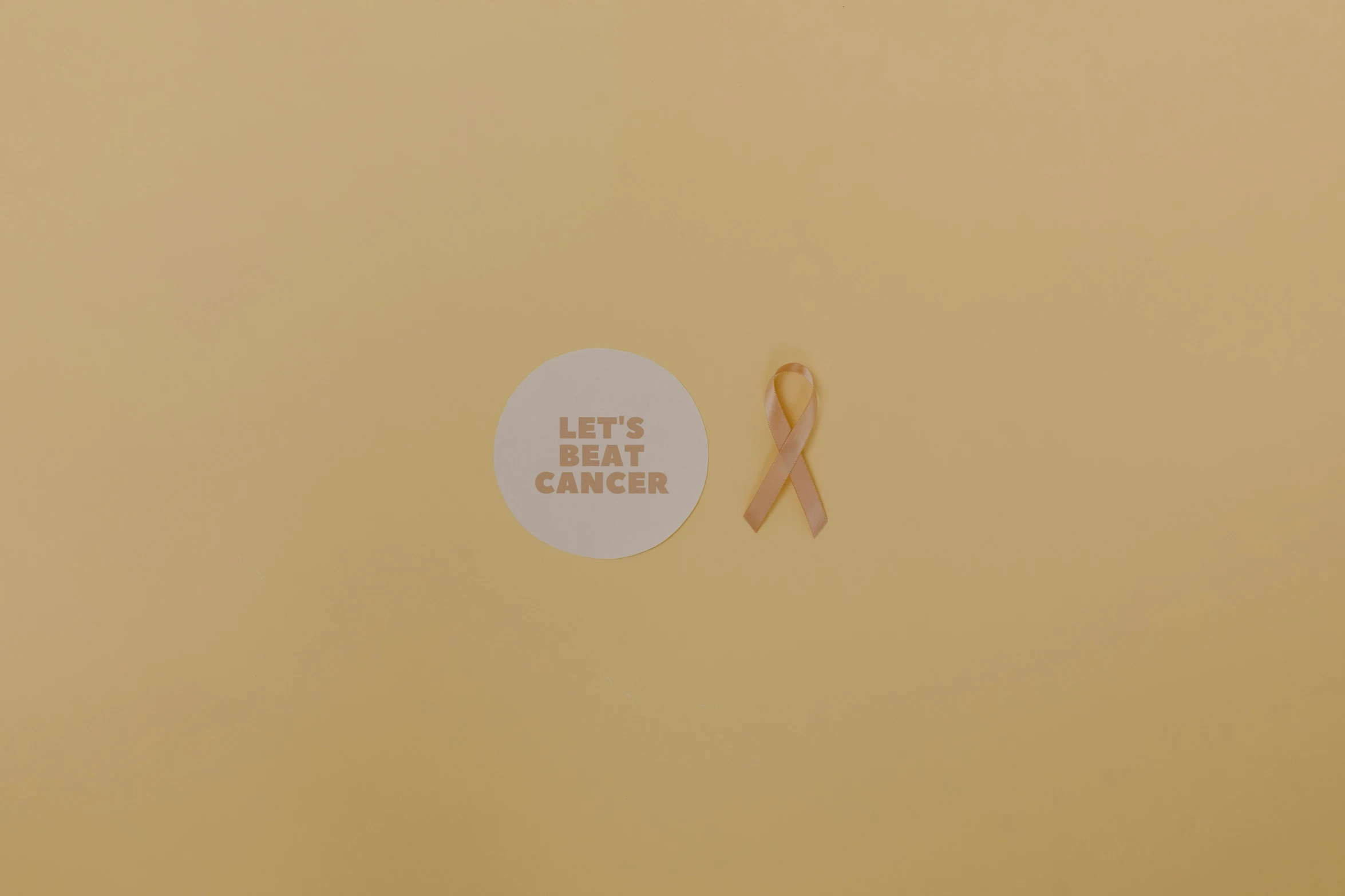 a pink ribbon next to a sticker that says let's beat cancer, an album cover, pexels contest winner, conceptual art, light - brown wall, ffffound, rinko kawauchi, ocher