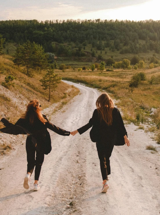 two women walking down a dirt road holding hands, a picture, by Lucia Peka, trending on pexels, renaissance, happy friend, on a mountain, on a canva, girls resting