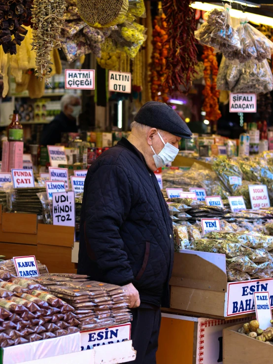 a man wearing a face mask in a market, a photo, thumbnail, baris yesilbas, profile image