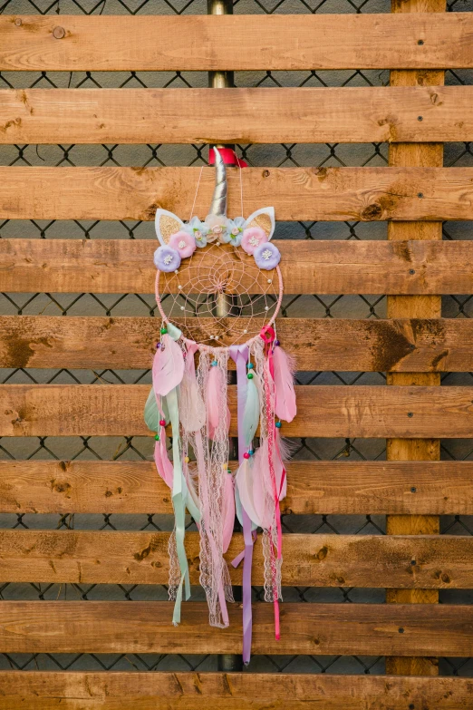 a little girl's dream catcher hanging on a fence, fully decorated, full product shot, a unicorn, kitty