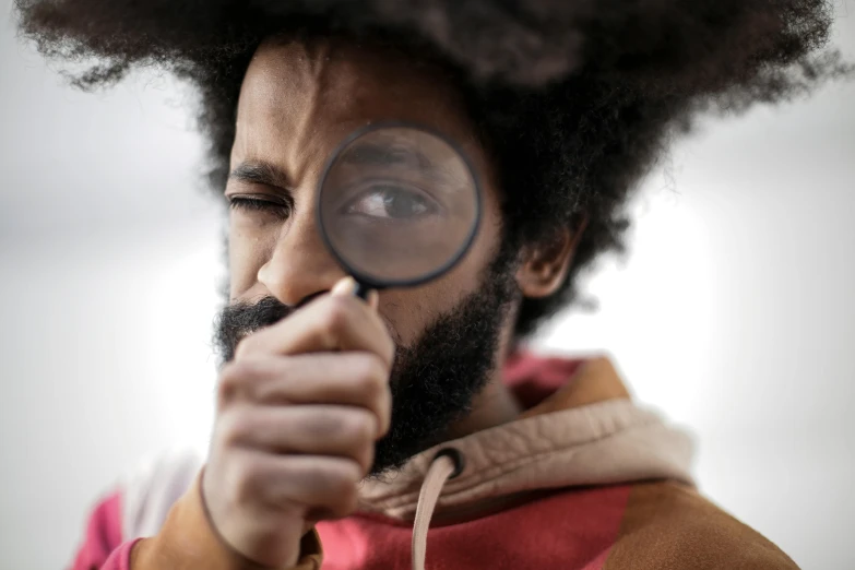 a man looking through a magnifying glass, trending on pexels, long afro hair, black curly beard, avatar image, medium close up shot