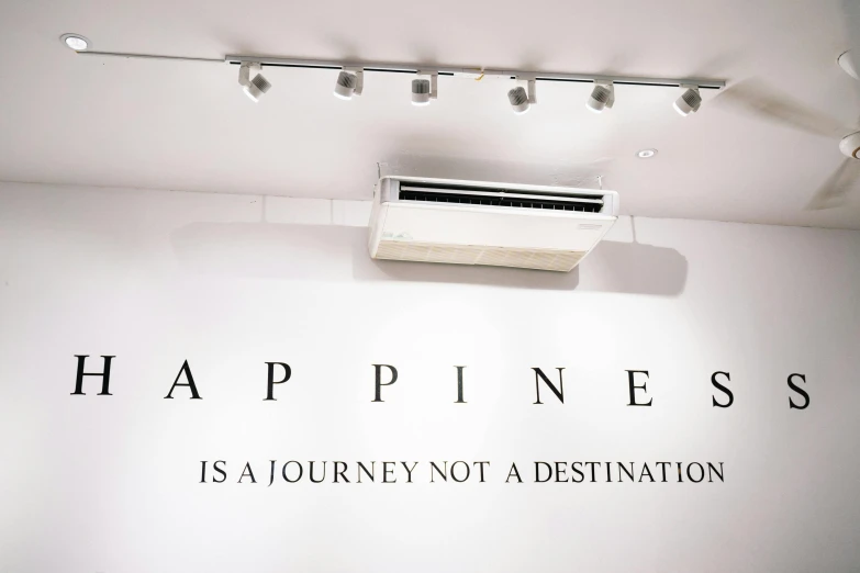 a sign that says happiness is a journey not a destination, inspired by Ding Yunpeng, minimalism, gallery lighting, air conditioner, no people, caparisons