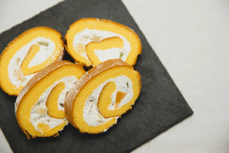 a black plate topped with slices of cake, inspired by Géza Dósa, unsplash, orange fluffy spines, uzumaki, corgi, 35 mm product photo”