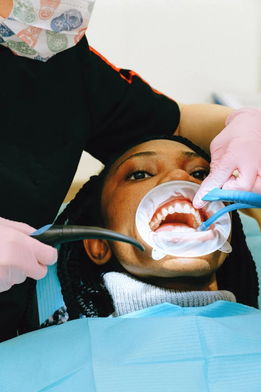 a little girl getting her teeth brushed by a dentist, by Lee Loughridge, renaissance, photo of a black woman, taken in the 2000s, translucent gills, sterile colours