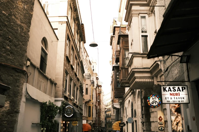 a group of people walking down a street next to tall buildings, a photo, by Lucia Peka, pexels contest winner, renaissance, greek, old shops, cables everywhere, 💋 💄 👠 👗