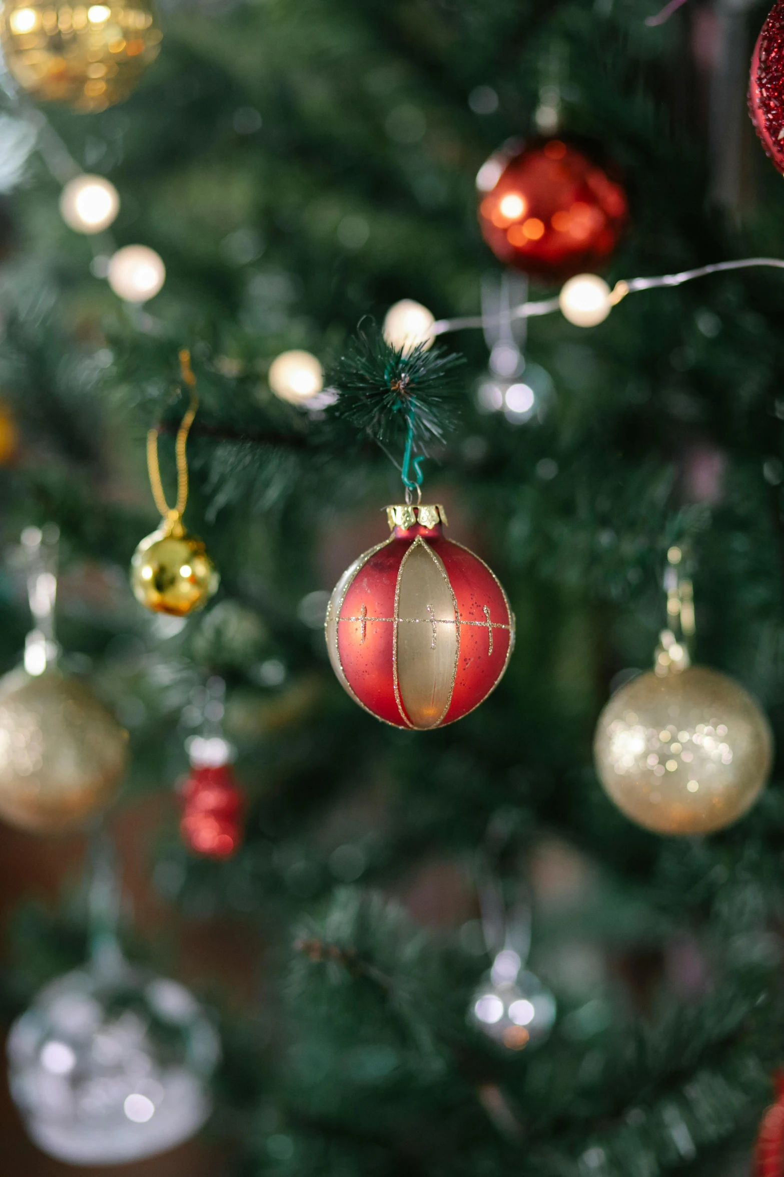 a close up of a christmas tree with ornaments, inspired by Ernest William Christmas, happening, gold and red, medium - shot, cosy, globes