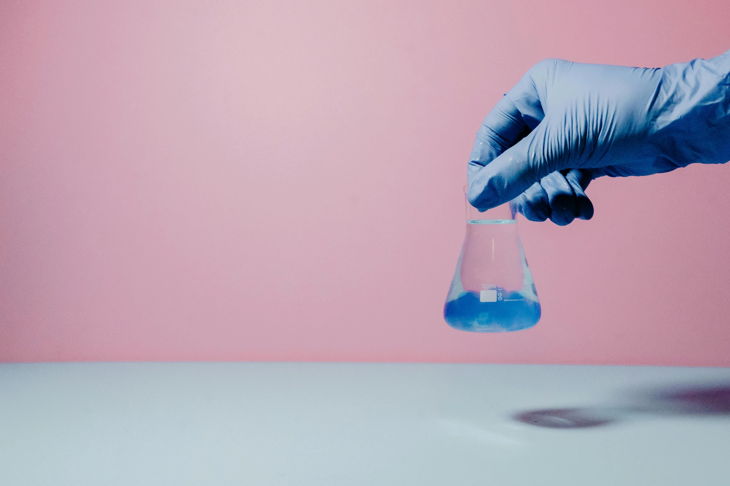 a hand in a blue glove holding a blue liquid, pexels, analytical art, soft blue and pink tints, medical lab, on display, backdrop