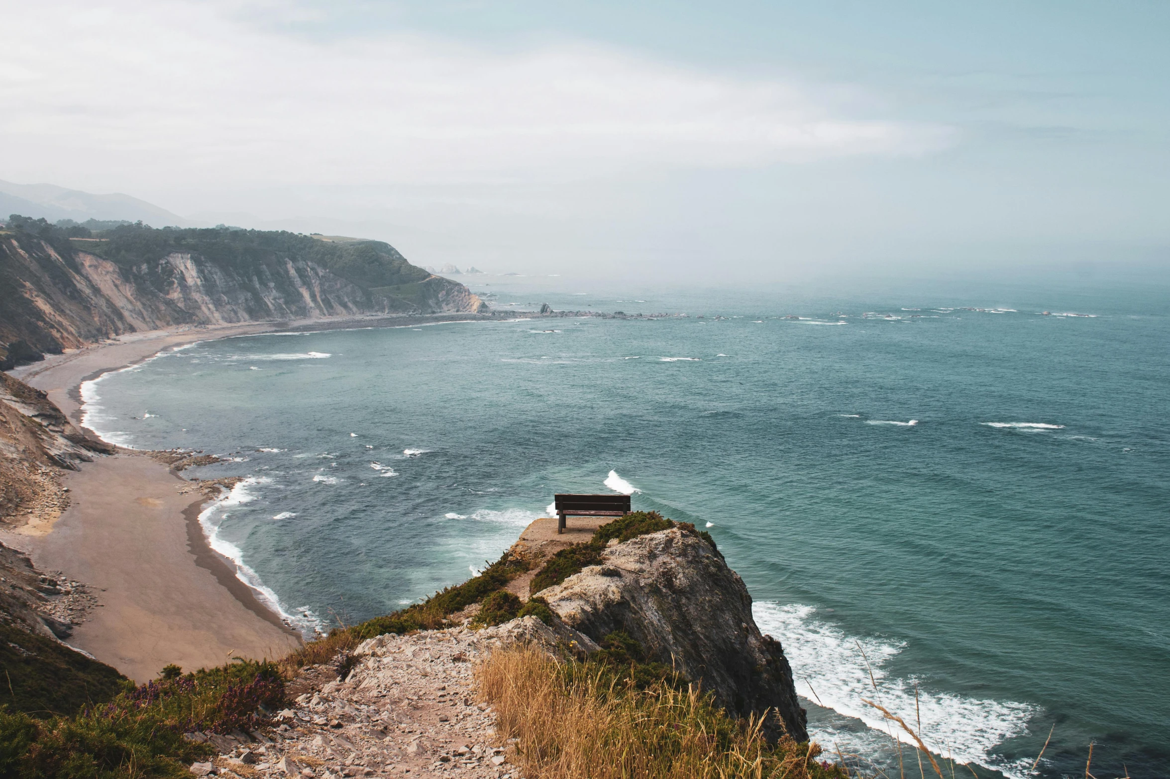 a bench sitting on top of a cliff next to the ocean, pexels contest winner, wood cabin in distance, omaha beach, concert, hazy water