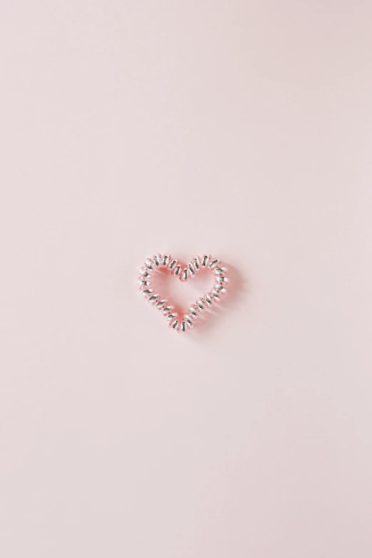 a heart shaped ring sitting on top of a pink surface, a picture, trending on pexels, striped, beautiful code, animation, intricate image