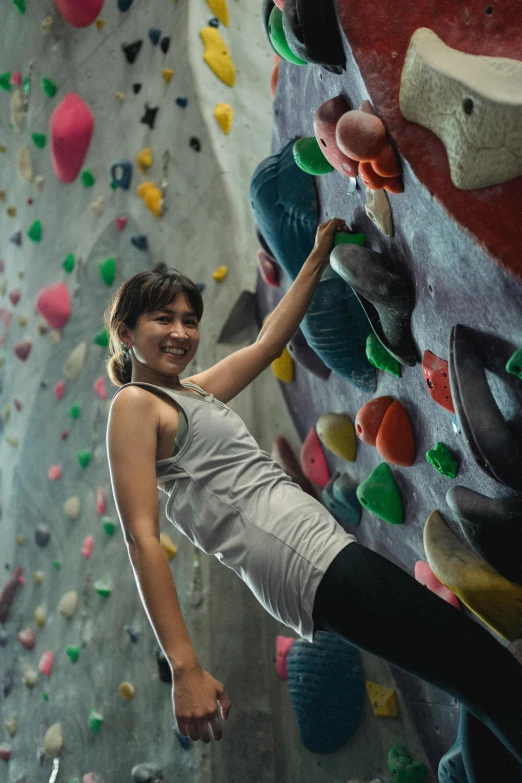 a woman climbing up the side of a rock wall, a portrait, pexels contest winner, in a gym, malaysian, promo image, everyone having fun