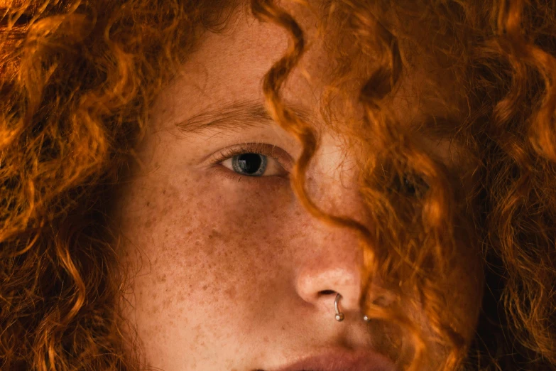 a close up of a woman with freckles on her face, an album cover, inspired by Elsa Bleda, trending on pexels, long curl red hair, red haired teen boy, unsplash photo contest winner, ignant