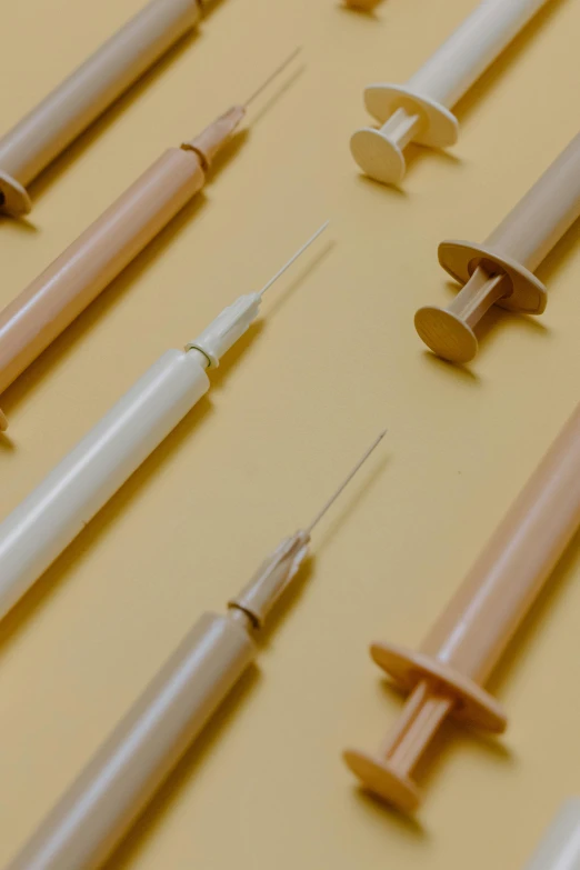 a bunch of syops sitting on top of a table, unsplash, plasticien, syringes, gradient brown to white, detailed product image, close up details