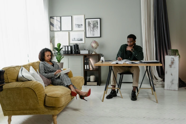 a man and woman sitting on a couch in a living room, pexels contest winner, working in an office, riyahd cassiem, niel davis, sitting on chair