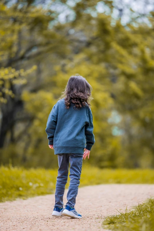 a little girl walking down a path in the woods, pexels, wearing sweatshirt, pondering, with his back turned, denim