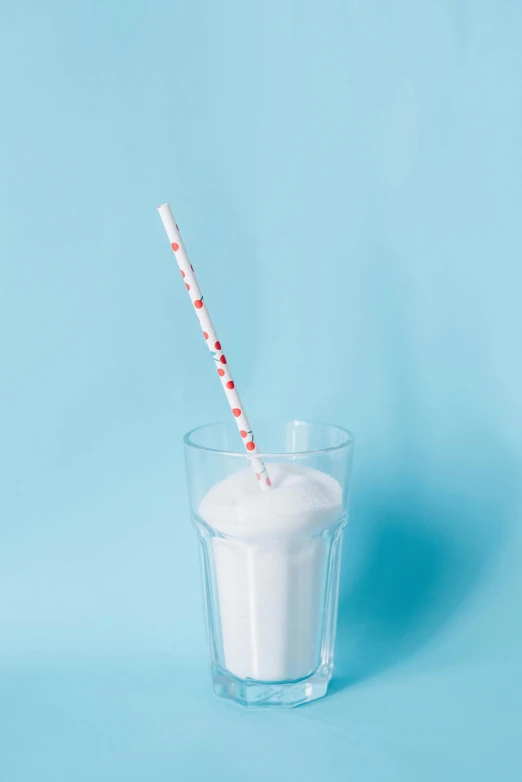 a glass of milk with a straw on a blue background, unsplash, magic realism, red white background, made of lab tissue, promo image, candy decorations