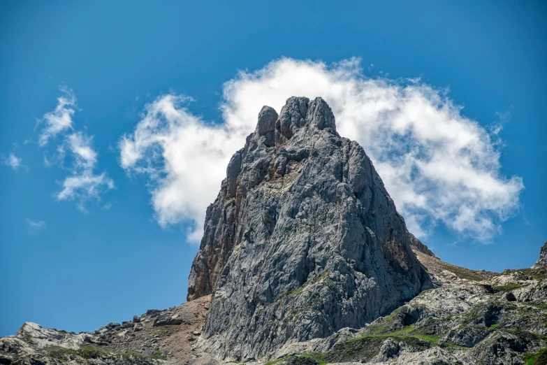 the top of a mountain with a cloud in the sky, by Carlo Martini, pexels contest winner, big sharp rock, thumbnail, high detail photo, nausicaa