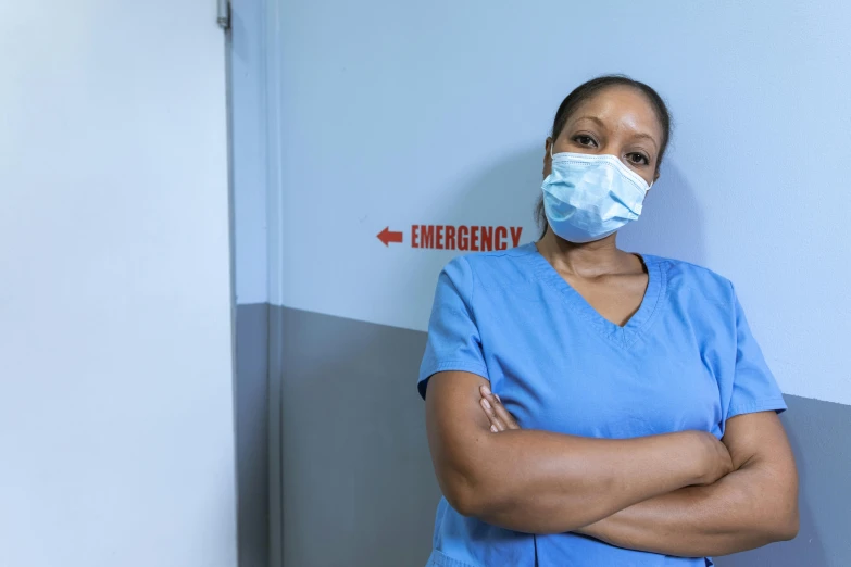 a woman in scrubs stands with her arms crossed, pexels contest winner, happening, avatar image, emergency room, photo of a black woman, redundancy