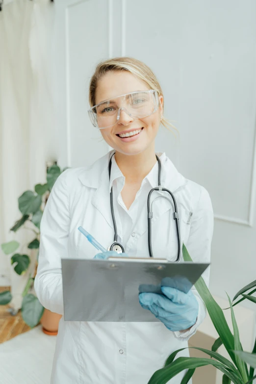 a female doctor holding a clipboard and smiling at the camera, a picture, shutterstock, renaissance, pastel', low quality photo, made of lab tissue, girl with glasses