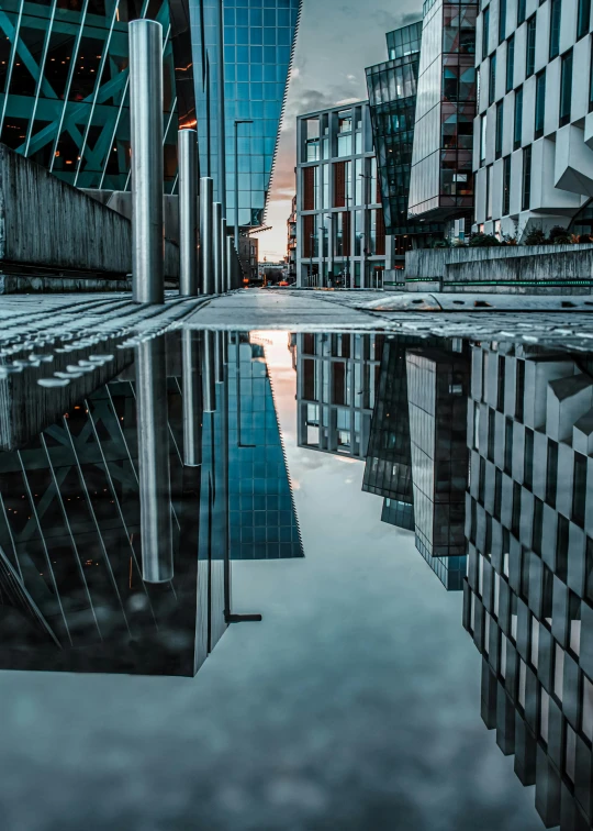 a reflection of buildings in a puddle of water, a picture, by Sebastian Spreng, unsplash contest winner, modernism, today\'s featured photograph 4k, wet reflections in square eyes, outdoor photo, sharp thick lines