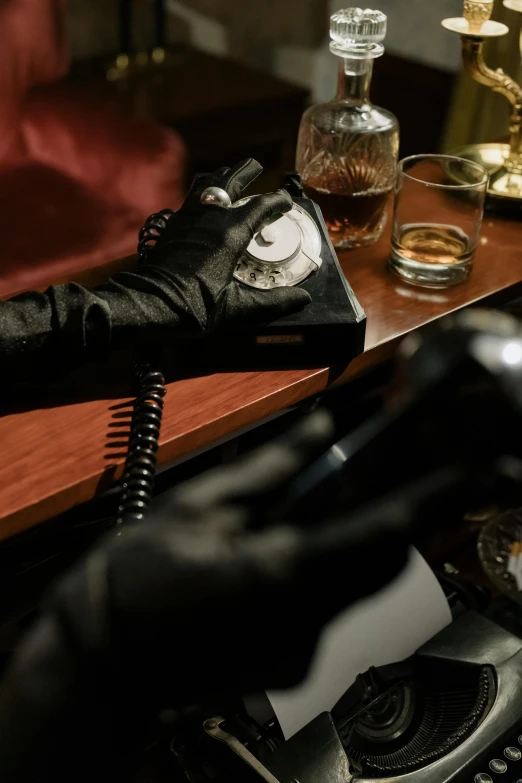 a person in black gloves sitting on a motorcycle, a still life, inspired by Nan Goldin, private press, table with microphones, cozy dark 1920s speakeasy bar, a telephone receiver in hand, drinking whiskey