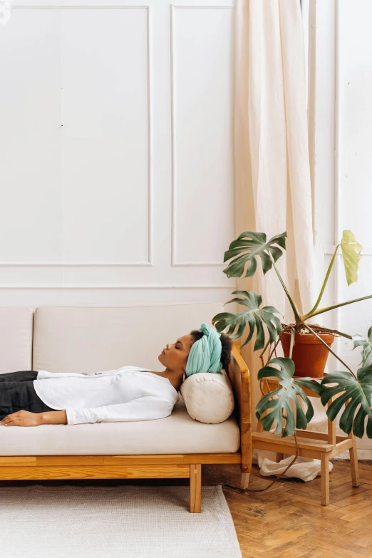 a person laying on a couch in a living room, inspired by Elsa Bleda, trending on pexels, houseplants, with a spine crown, snoring, with a white background