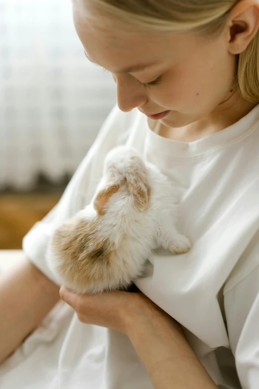 a woman holding a small hamster in her arms, by Eizan Kikukawa, pexels contest winner, renaissance, dressed in a white t-shirt, cat bunny, profile image, the birth