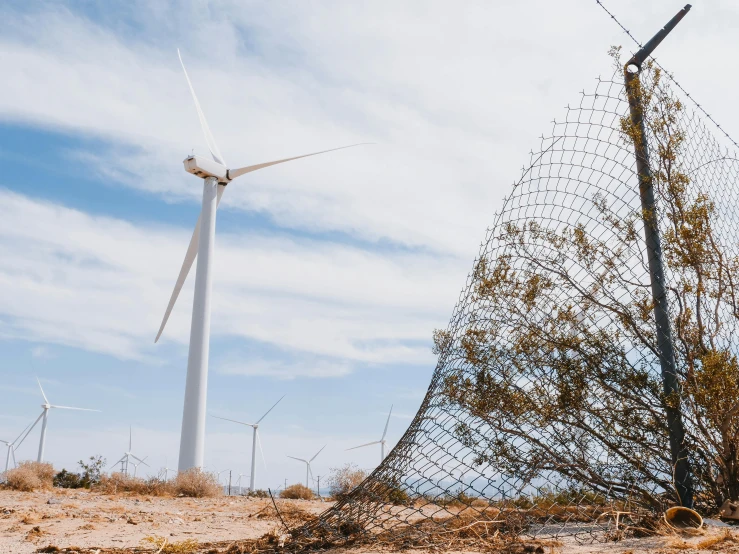 a fenced off area with wind turbines in the background, unsplash contest winner, environmental art, future miramar, made of wire, promo image, joel sternfeld