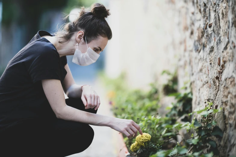 a woman in a face mask picking flowers, pexels contest winner, avatar image, grieving, australian, healthcare worker