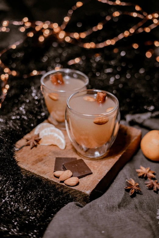 two glasses filled with drinks sitting on top of a table, a still life, by Julia Pishtar, pexels, cinnamon, stars, soup, square