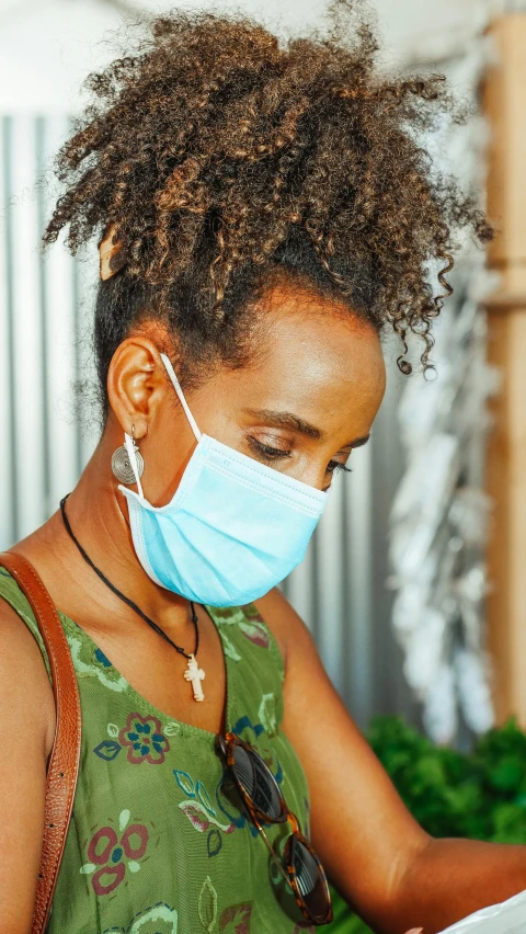 a woman wearing a face mask reading a book, by Daniel Lieske, pexels, ethiopian, square, 15081959 21121991 01012000 4k, medical mask