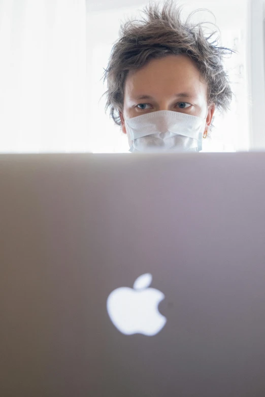 a man sitting in front of a laptop wearing a face mask, a stock photo, by Dan Luvisi, happening, apple, closeup!!, large)}], # oc